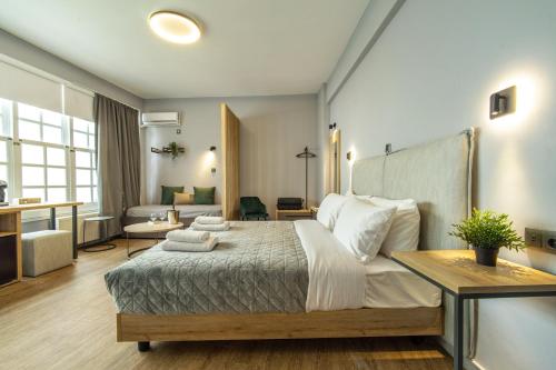 een slaapkamer met een groot bed en een woonkamer bij Karma Athens II in Athene