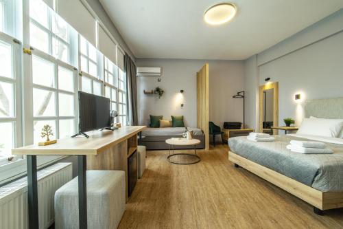 een slaapkamer met een bed en een bureau met een televisie bij Karma Athens II in Athene