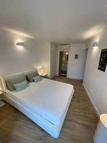 a large white bed in a room with wooden floors at Au cœur de la Vieille Ville in Ajaccio