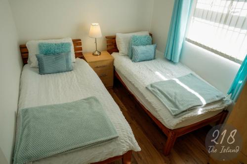two twin beds in a room with a window at The Cabin, Glan Gwna in Caernarfon