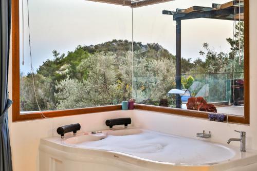 a bathroom with a large window and a sink at Villa Fio Duo in Kas