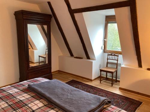 um quarto com uma cama, um espelho e uma cadeira em The Lion House em Mouzens