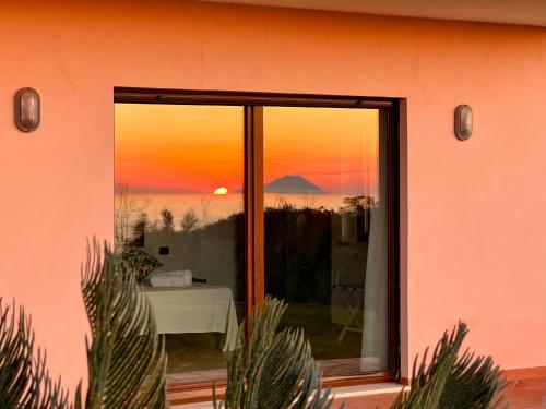 a sunset seen through a window of a pink house at GREEN APARTMENT in VILLA ANGISI in Drapia