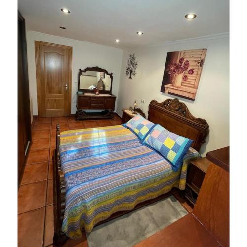 a bedroom with a large bed and a mirror at La Casina de Iris in Cudillero
