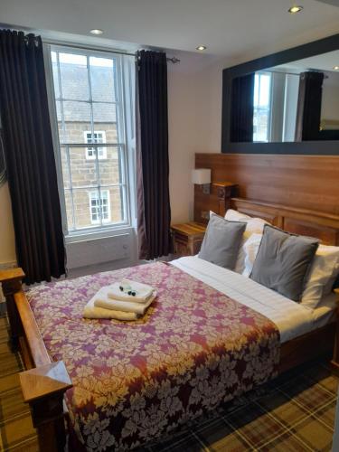 a bedroom with a large bed with a large window at Schooner Hotel in Alnmouth