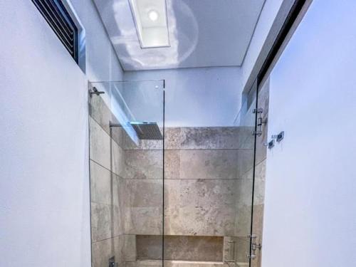 een douche met een glazen deur in de badkamer bij Casa Quinta de Lujo Villeta MyS in Villeta