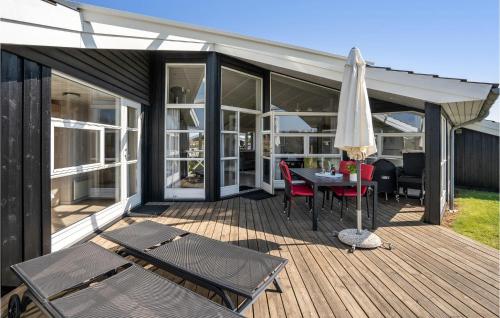 a patio with a table and an umbrella on a deck at Cozy Home In Haderslev With Sauna in Haderslev