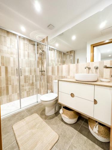a bathroom with a toilet and a sink and a shower at El Olivo by ALÔGA in Corcubión