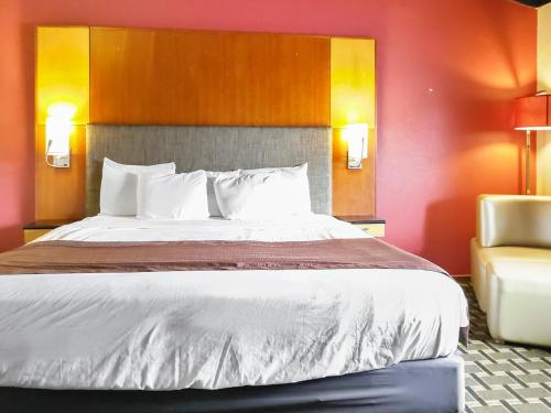 a large bed in a hotel room with a chair at Americas Best Value Inn Hinckley in Hinckley