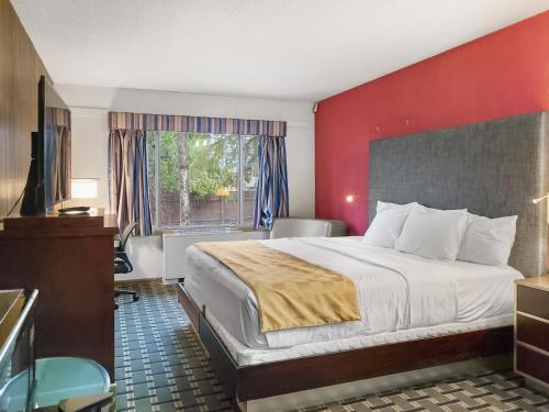 a hotel room with a large bed and a window at Americas Best Value Inn Hinckley in Hinckley