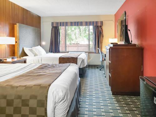 a hotel room with two beds and a flat screen tv at Americas Best Value Inn Hinckley in Hinckley