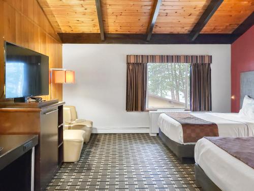 a hotel room with two beds and a flat screen tv at Americas Best Value Inn Hinckley in Hinckley