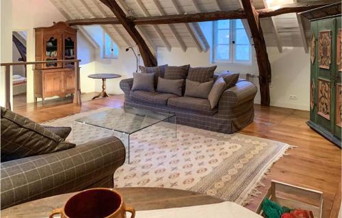 un salon avec deux canapés et une table en verre dans l'établissement Amazing Home In Sarrazac With Wifi, à Sarrazac