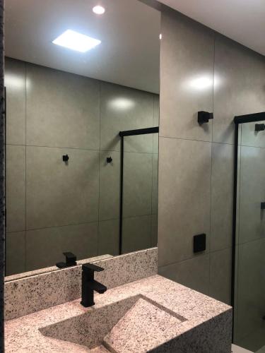 a bathroom with a shower with a large mirror at ESCARPAS FLATS in Capitólio
