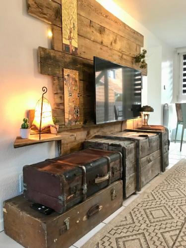 - un salon avec un coffre ancien et une télévision dans l'établissement Gîte plain-Pied avec jardin du Centre Alsace, à Ebersheim