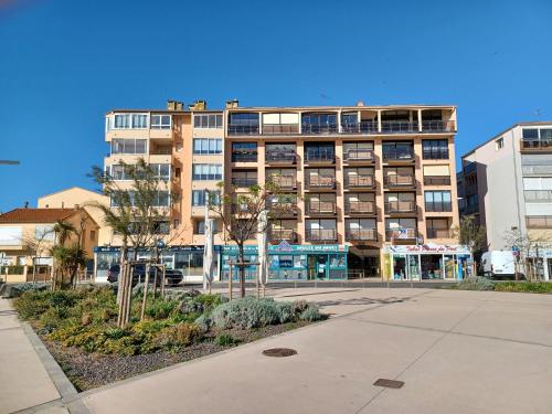 a tall building with a parking lot in front of it at Studio hypercentre vue mer in Valras-Plage