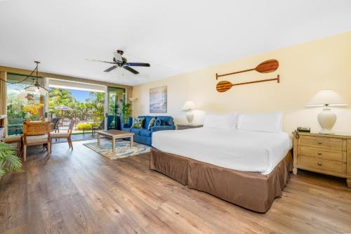 a bedroom with a bed and a living room at Maui Eldorado E106 in Kahana