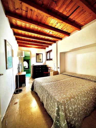 a bedroom with a bed and a wooden ceiling at Welcome Traveller VILLA ARIGONI in Garda