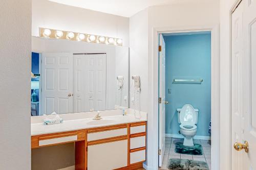 La salle de bains est pourvue de toilettes, d'un lavabo et d'un miroir. dans l'établissement Pointe Royale Golf Front Condo, à Branson