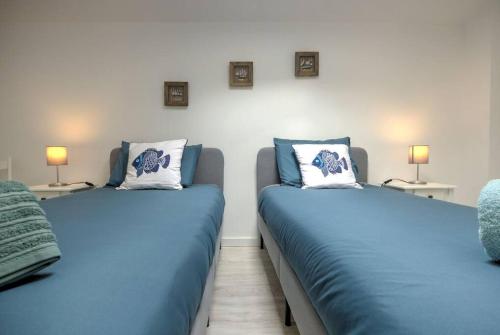 two blue beds in a room with two lamps at Sesimbra Loft in Sesimbra