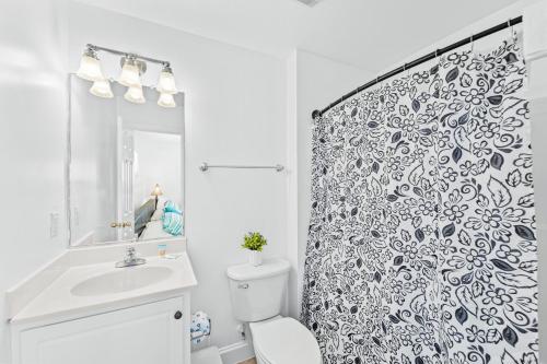 a bathroom with a toilet and a shower curtain at Sound Happy in Rodanthe