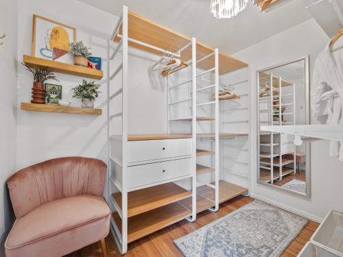 a room with white shelving and a pink chair at Beach Essentials&bikes - Backyard&patios in San Diego