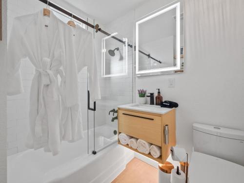 uma casa de banho branca com um chuveiro e um lavatório. em Saunabackyardbikesbeach Shedfire Pit em San Diego