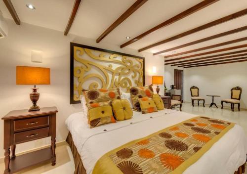 a bedroom with a bed and a table and chairs at Hotel Dorado Plaza Boutique Calle del Arsenal in Cartagena de Indias