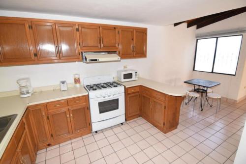 a kitchen with wooden cabinets and a white stove top oven at Condo 3 Easy Walk to San Felipe Malecon in San Felipe