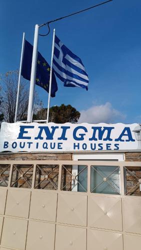 two flags flying on top of a building with a sign at Enigma Boutique Houses Koxyli in Marmarion