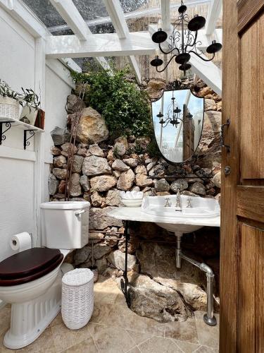 a stone bathroom with a toilet and a sink at Luxury Villa Ciao Cocoa in Grimaldi