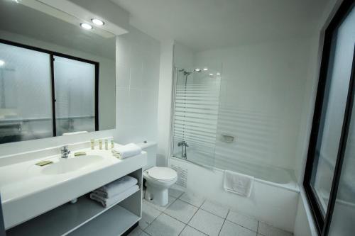 a bathroom with a sink and a toilet and a shower at Tempo Rent Apart Hotel in Santiago
