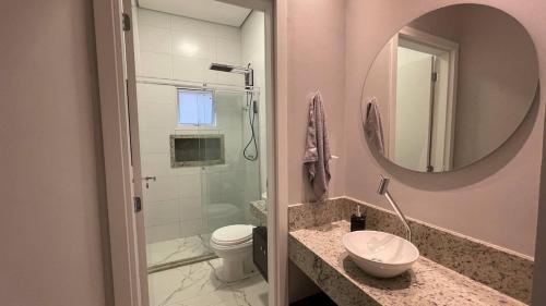 a bathroom with a sink and a toilet and a mirror at Casa com piscina 1 Quarto in Rondonópolis