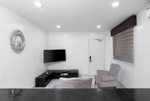 a living room with two chairs and a tv at BKT Cribs - Apartments & Suites in Abuja