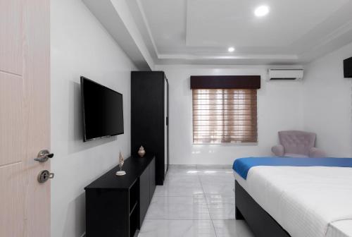 a bedroom with a bed and a flat screen tv at BKT Cribs - Apartments & Suites in Abuja
