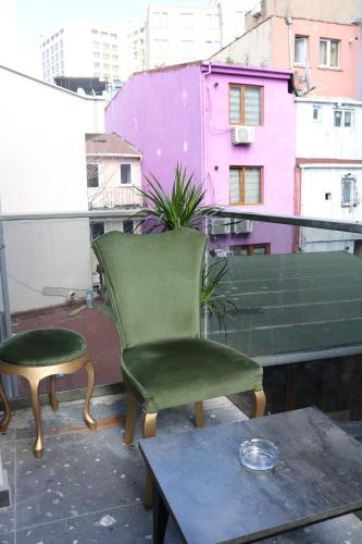 a green chair and a stool on a balcony at Ortek Hotel Taksim in Istanbul