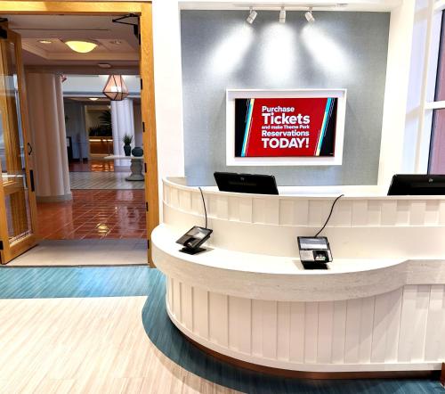 a lobby with a waiting area with a sign on the wall at Walt Disney World Swan Reserve in Orlando