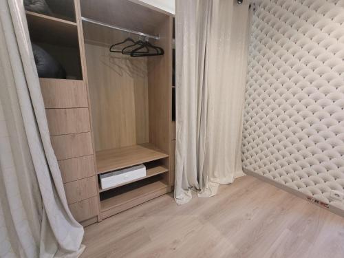 een kamer met een kast met een bed en gordijnen bij La maison des castors -1 flat and 1 studio in Bièvres