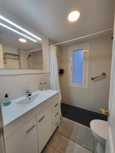 a bathroom with a sink and a toilet and a mirror at Waikiki 47 in Corralejo