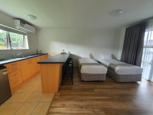 a room with a kitchen with a table and a couch at Ocean Inn Motel in Auckland