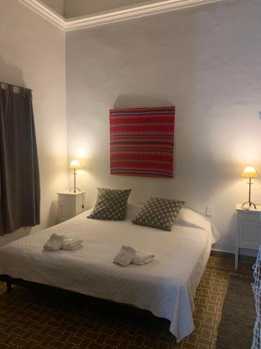 ein Schlafzimmer mit einem großen weißen Bett mit zwei Kissen in der Unterkunft Casona Leguizamon in Salta