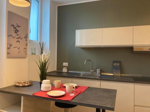 a kitchen with a table with cups and plates on it at Fiera City Life 2 Top Apartment in Milan