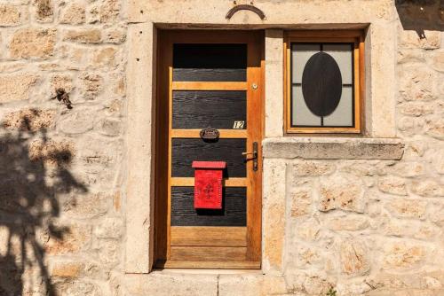 une porte dans un bâtiment en pierre avec une boîte rouge dans l'établissement City Center Studio Nest, à Makarska