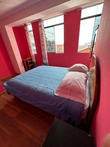 ein Schlafzimmer mit einem Bett in einem Zimmer mit roten Wänden in der Unterkunft CASA SANTIAGO in Cusco