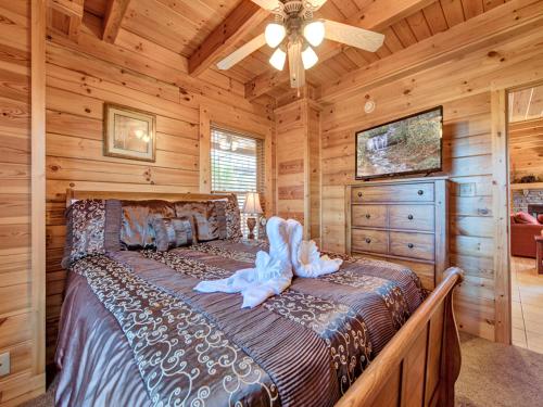 a bedroom with a bed in a log cabin at Misty Mountain Hideaway, 3 Bedrooms, Sleeps 10, Pool Access, WiFi in Pigeon Forge