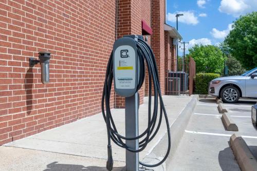 a parking meter with a hose attached to a brick building at Best Western Plus Duncanville Dallas in Duncanville