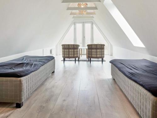 two beds and two chairs in a room at 8 person holiday home in Nexø-By Traum in Neksø