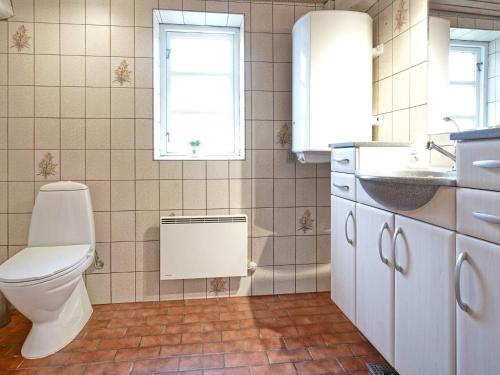 een badkamer met een toilet, een wastafel en een raam bij Holiday home Nexø XLIII in Neksø