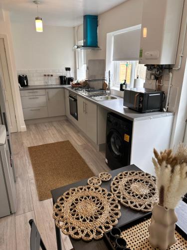 a kitchen with a table with a microwave and a stove at The Maison- Cozy home stay in Nottingham