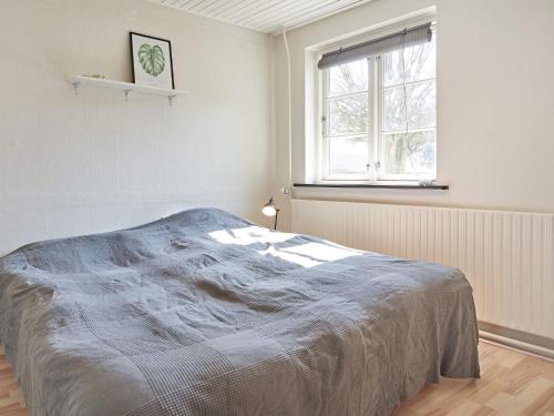 - une chambre blanche avec un lit et une fenêtre dans l'établissement Holiday home Aakirkeby XLV, à Åkirkeby